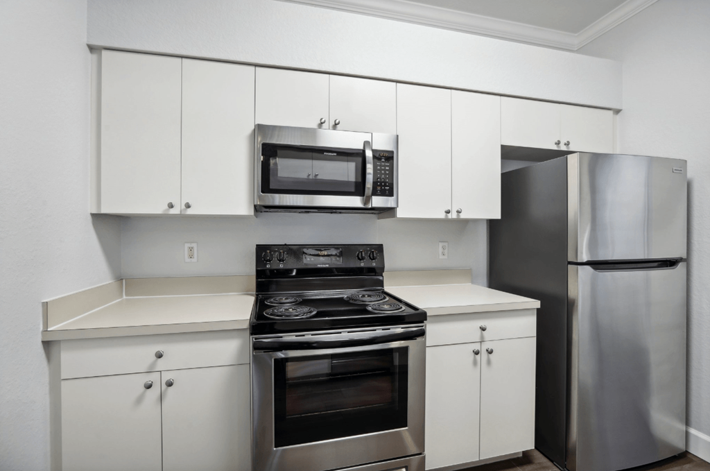 A modern kitchen with stainless steel appliances and white cabinets.